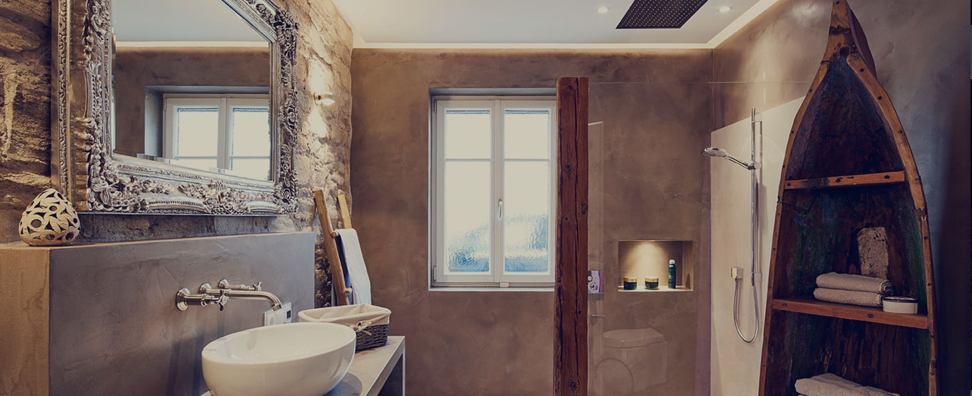 Modern gestaltetes Badezimmer mit Natursteinwand, großem Spiegel, Waschtisch und offener Dusche